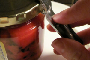 Use a bottle opener to pry open a stuck jar top